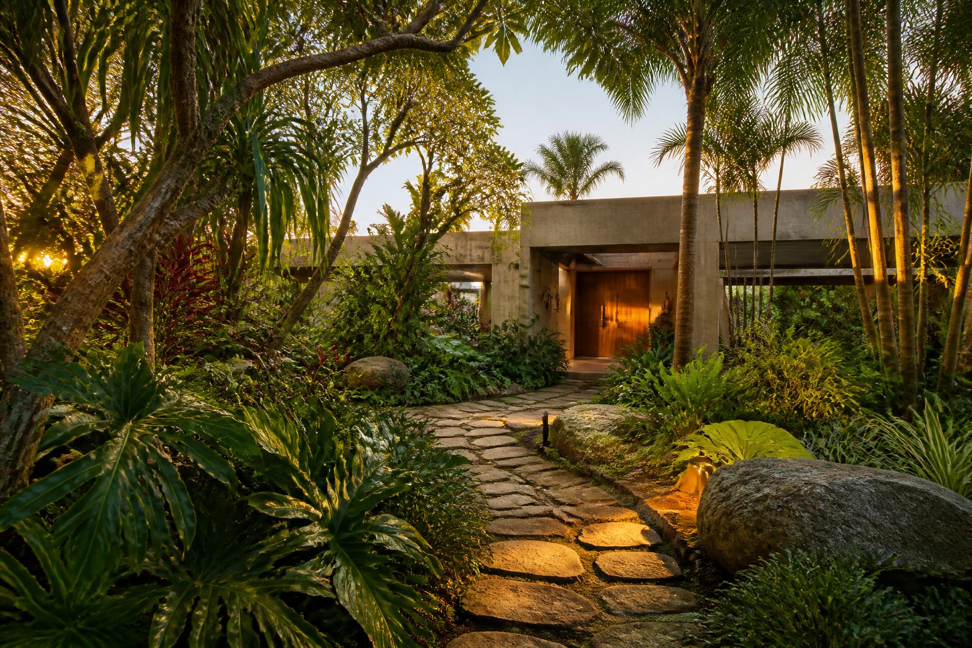 Jardim tropical residencial com vegetação densa e caminho de pedra